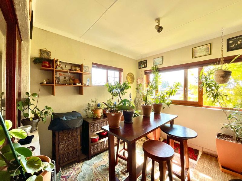 A sunlit enclosed patio or sunroom featuring timber-framed windows and a neutral color palette, offering a bright and versatile space.