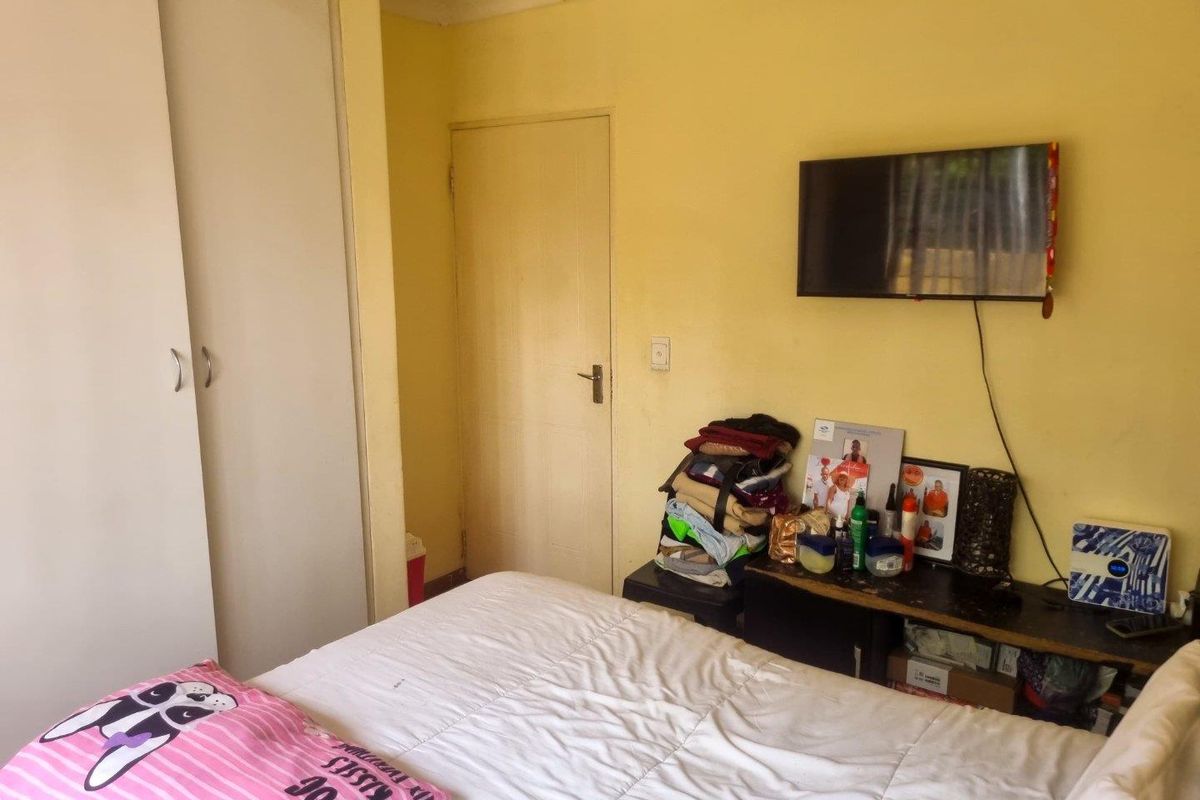A bedroom featuring built-in sliding door cupboards and a wall-mounted television point.