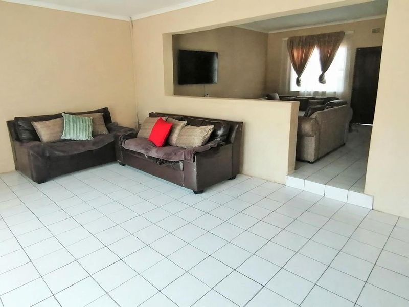 Open plan living area featuring ceramic floor tiles and a central partition wall, providing a versatile layout for multiple living spaces.
