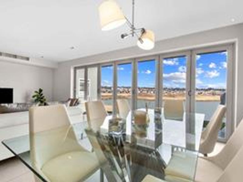 Bright open-plan living and dining area featuring large bi-fold glass doors that provide seamless access to the outdoors and expansive views.