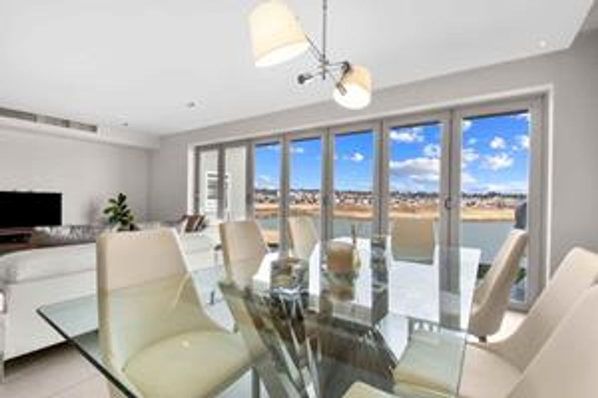 Bright open-plan living and dining area featuring large bi-fold glass doors that provide seamless access to the outdoors and expansive views.
