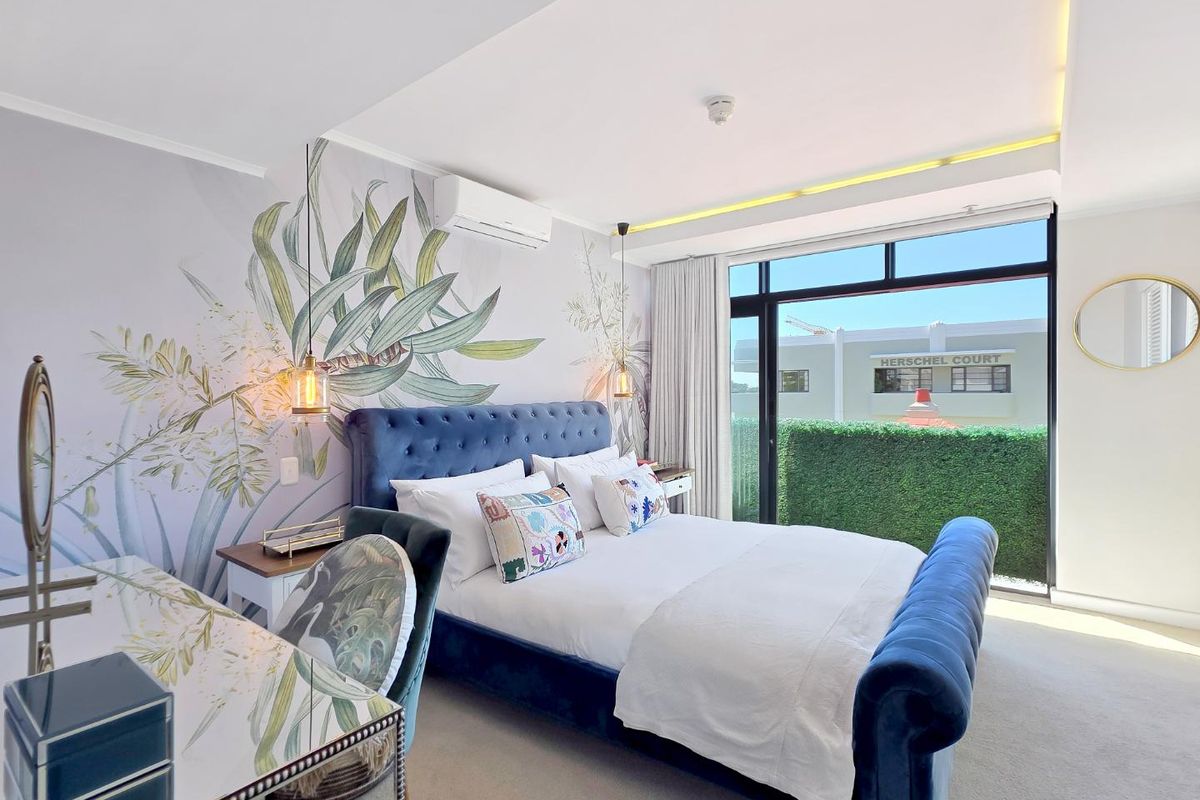A well-maintained bedroom featuring a large sliding glass door, recessed ceiling lighting, and a split-system air conditioner.