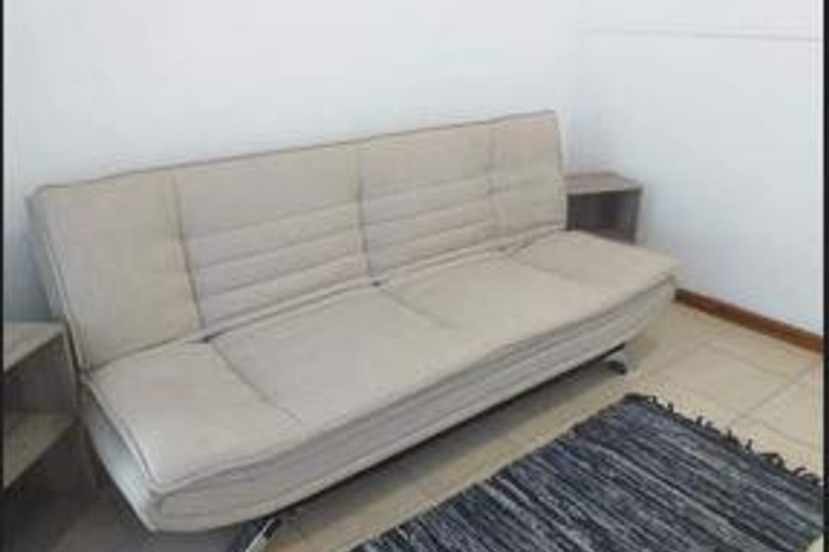 A simple living area featuring tiled flooring and neutral wall finishes.