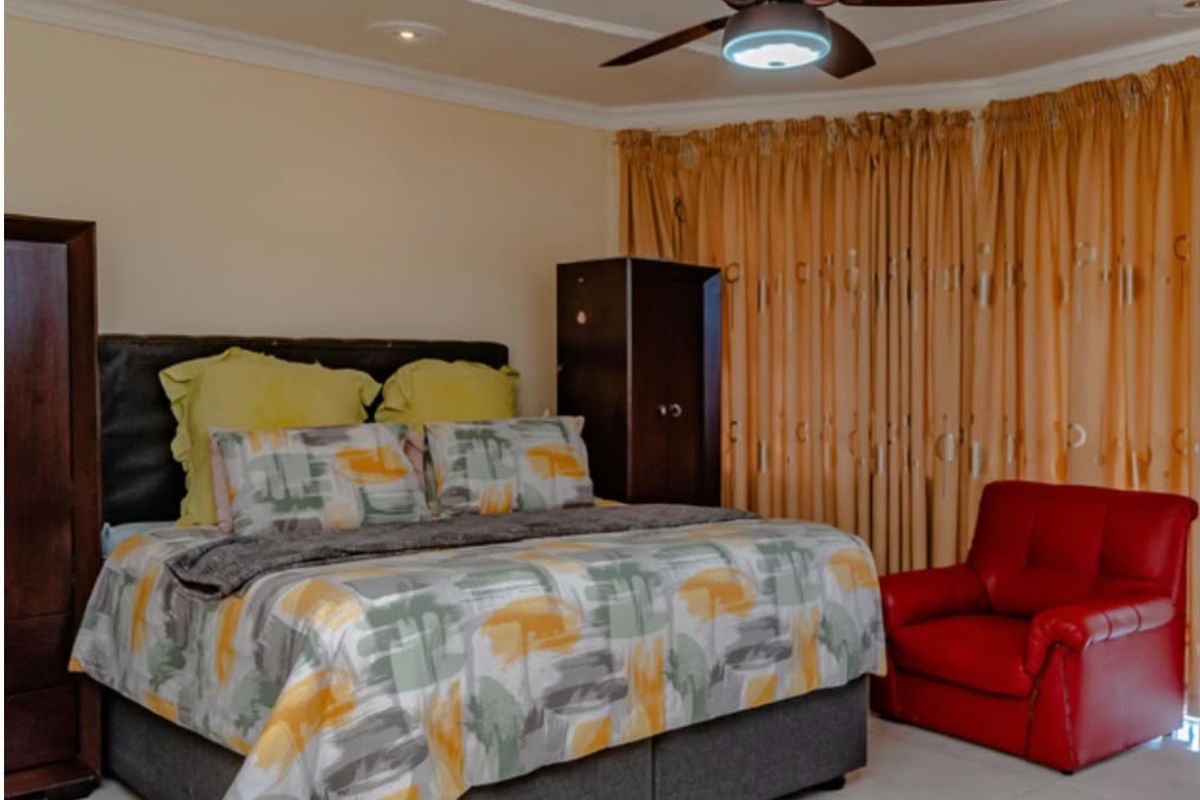 A bedroom featuring tiled flooring, a ceiling fan with a decorative ceiling rose, and coving detail.