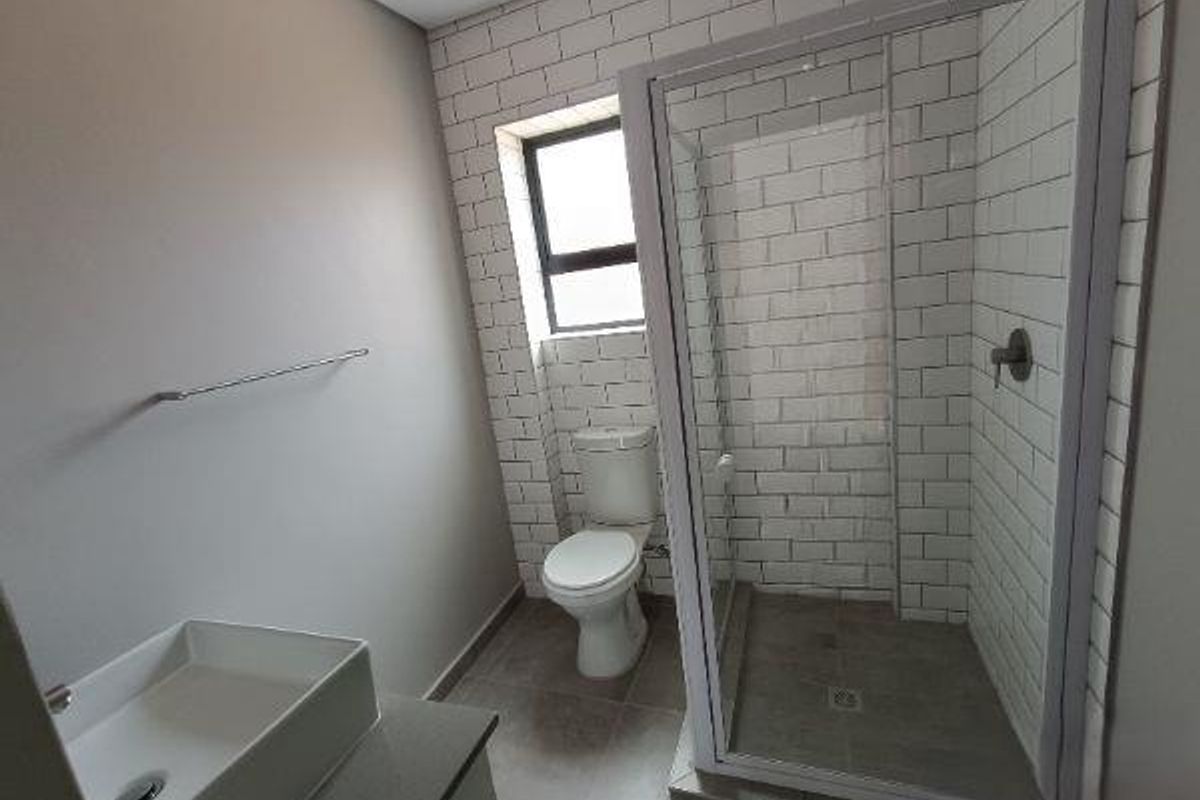 Modern bathroom featuring a glass-enclosed shower, subway tile wall finishes, a vessel sink on a vanity, and a standard toilet.