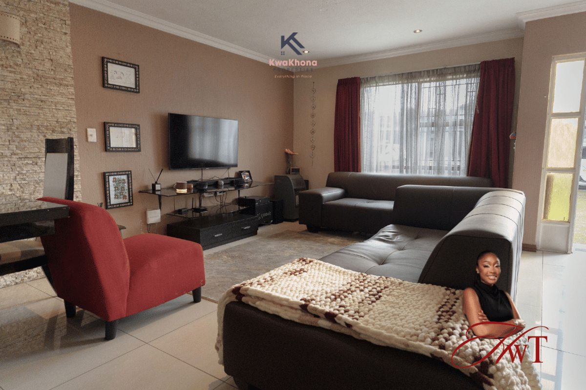 A comfortable living room featuring tiled flooring, a textured stone feature wall, and recessed lighting, providing a warm and inviting space for relaxation.