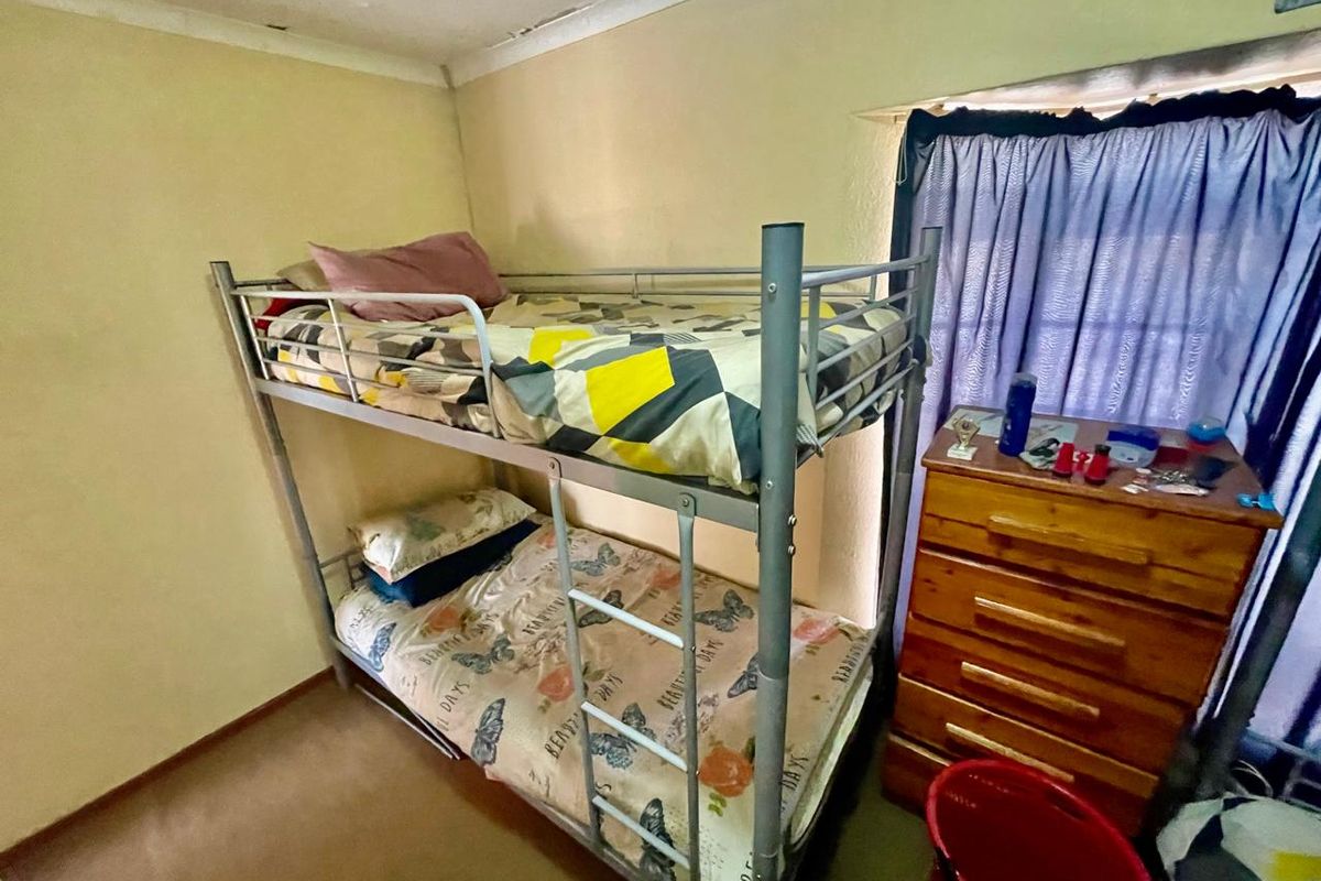 A compact bedroom featuring coved ceilings, currently showing signs of water damage and peeling paint on the ceiling surface.