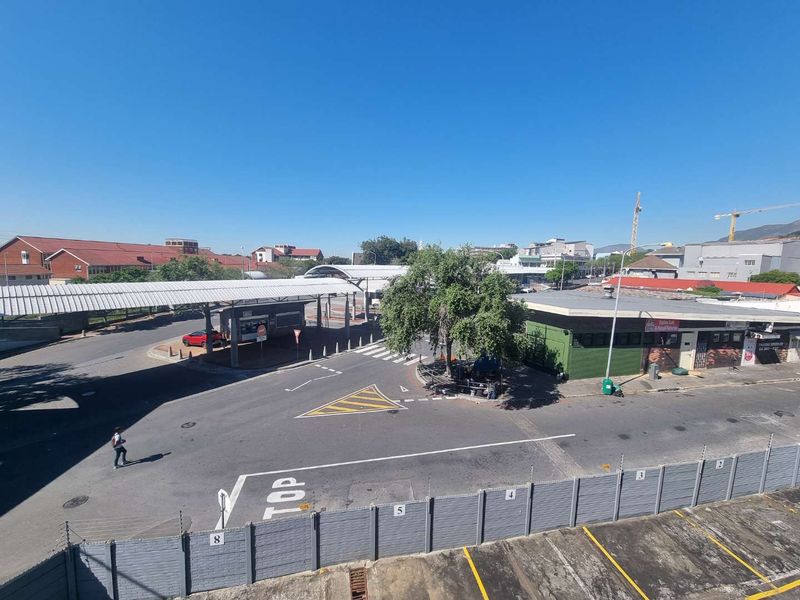 An elevated view overlooking a local street intersection, parking area, and surrounding commercial infrastructure.