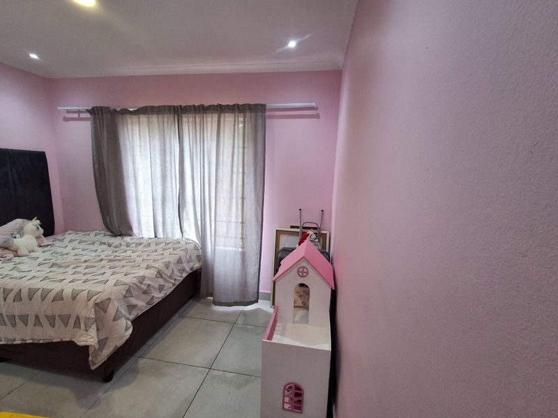 A bedroom featuring tiled flooring, recessed downlighting, and a window with a curtain rod.