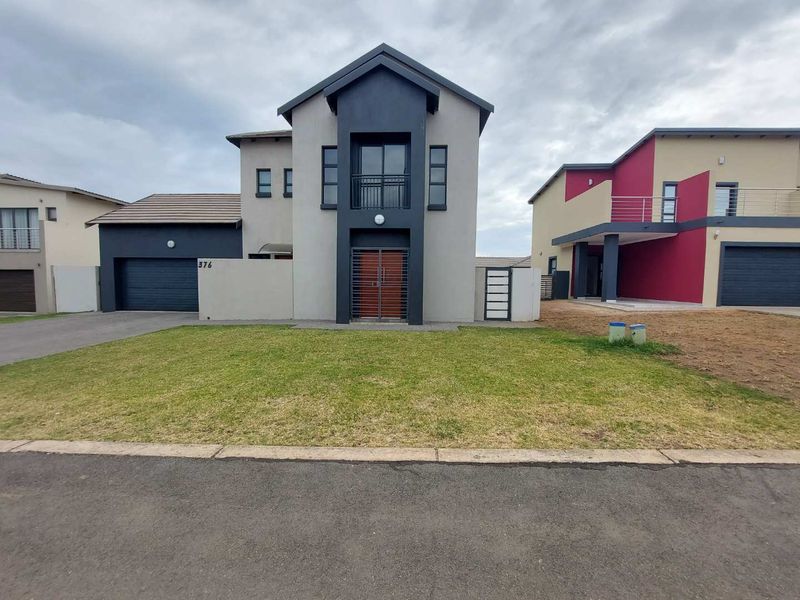 Modern double-story residential home featuring a contemporary facade, integrated double garage, and an upper-level balcony with a secure entrance.