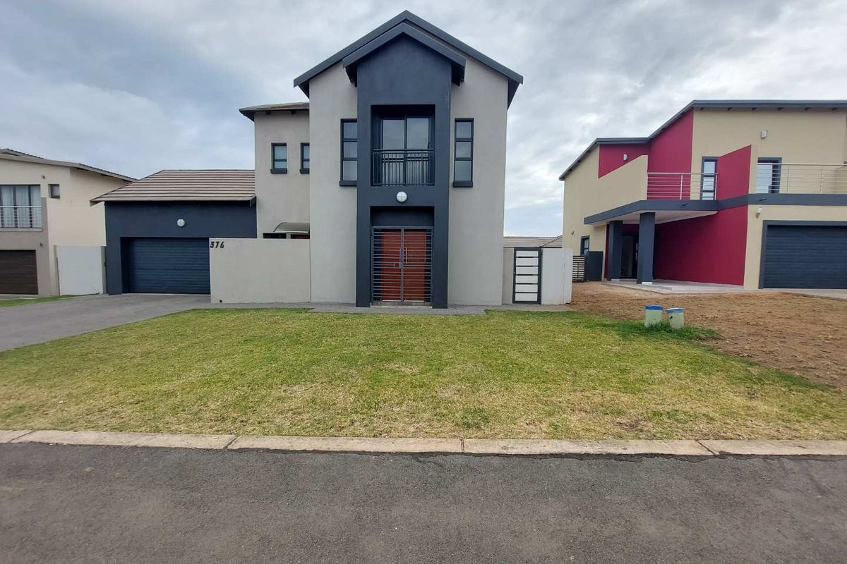 Modern double-story residential home featuring a contemporary facade, integrated double garage, and an upper-level balcony with a secure entrance.