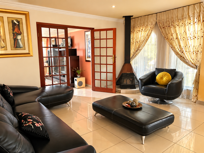 A bright living room featuring polished tiled floors, a modern freestanding fireplace, and classic wooden french doors leading to an adjacent space.