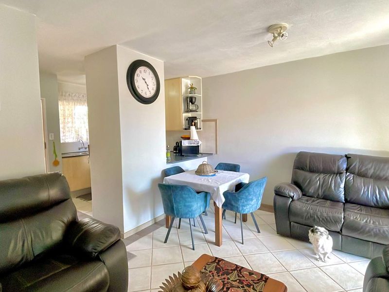 Open plan living and dining area featuring tiled flooring and a partial view into the kitchen space.