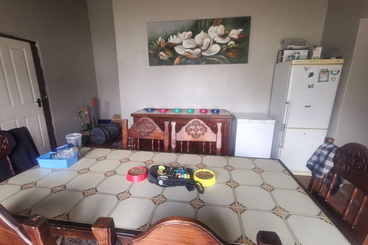 A dining area featuring a tiled table and visible wall cracks, requiring maintenance and cosmetic updates to improve the overall aesthetic.