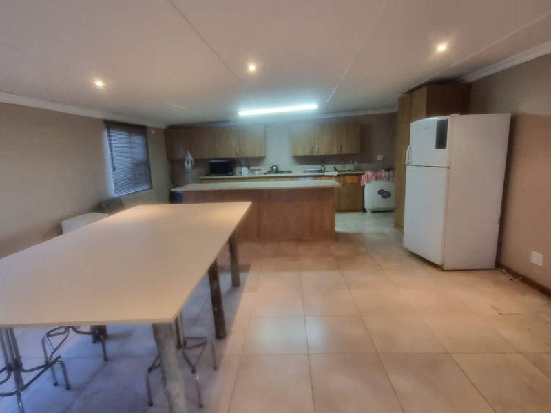 Spacious kitchen featuring built-in cabinetry, a central island, and tiled flooring, offering a functional layout with potential for modern updates.