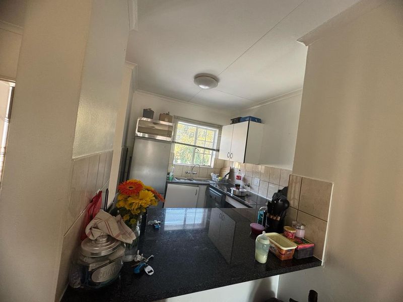A functional kitchen featuring granite countertops, tiled backsplash, and built-in cabinetry, offering a practical layout for daily meal preparation.