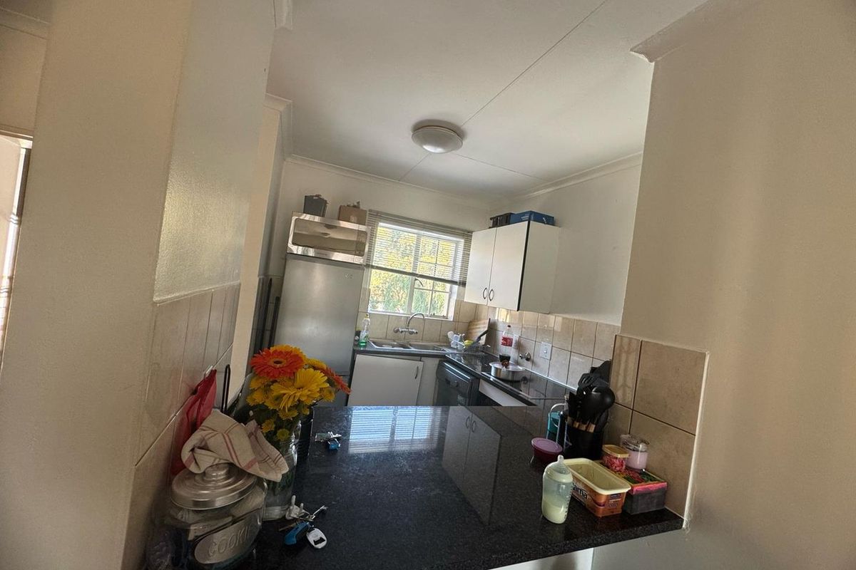 A functional kitchen featuring granite countertops, tiled backsplash, and built-in cabinetry, offering a practical layout for daily meal preparation.