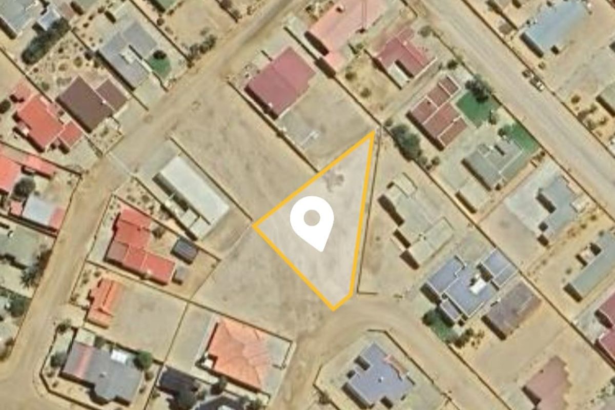 An aerial view of a vacant residential land parcel situated within an established neighborhood, highlighting the property boundaries and surrounding street layout.