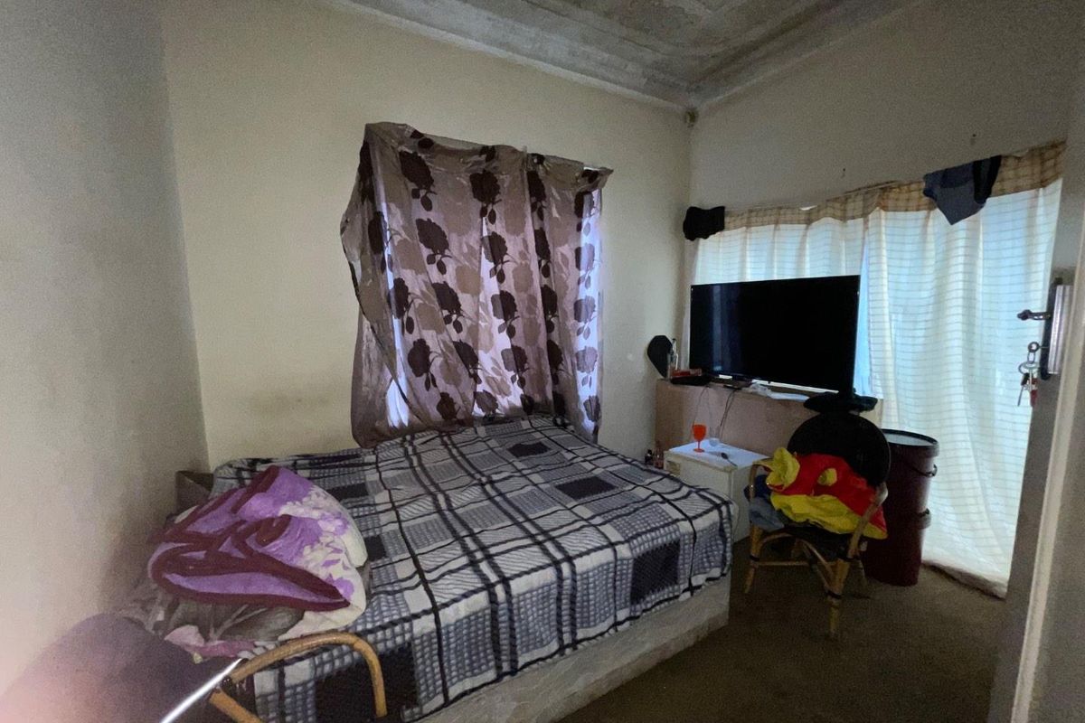 A bedroom featuring a standard layout with visible ceiling deterioration and dated finishes, offering potential for cosmetic renovation.