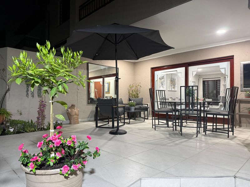 A well-maintained covered patio area featuring large format floor tiles and sliding glass doors providing seamless access to the interior living space.
