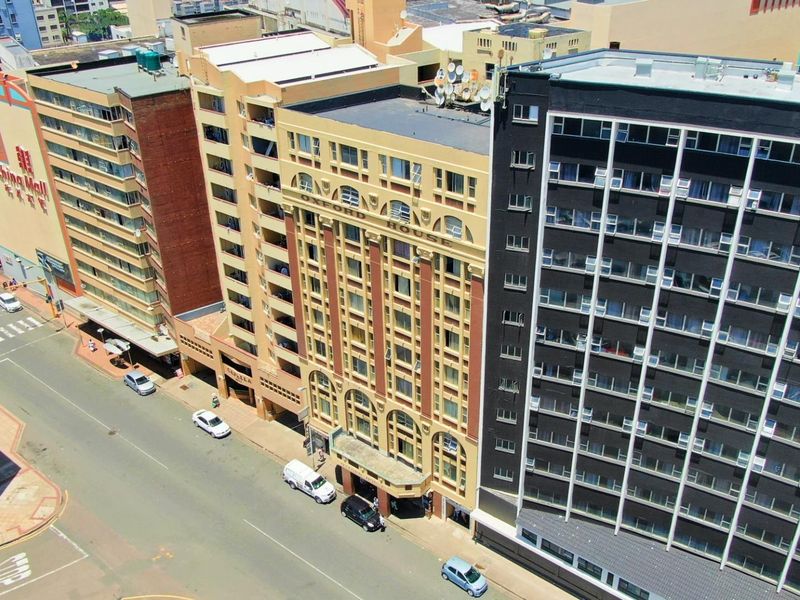 An aerial view of a city street featuring the Oxford House apartment building and surrounding urban infrastructure.