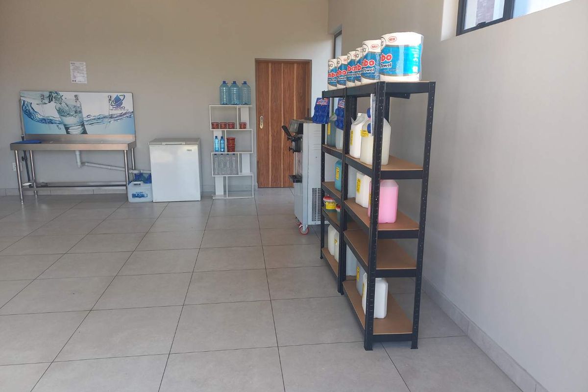A functional utility or storage space featuring tiled flooring, a stainless steel sink, and direct access via an internal door.