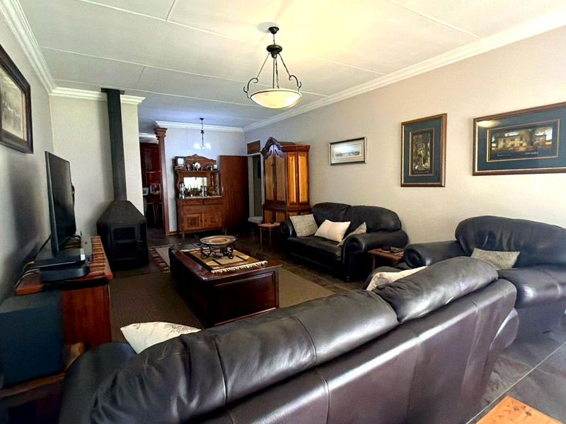 A spacious living room featuring a freestanding fireplace, neutral wall finishes, and classic ceiling cornicing, providing a comfortable and functional family living area.