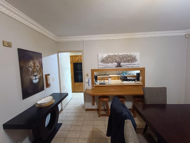 Open plan living and dining area featuring a built-in breakfast bar with a pass-through window connecting to the kitchen.