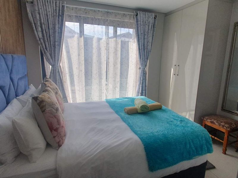 A well-maintained bedroom featuring built-in wardrobes and decorative slatted wood wall paneling, providing a clean and functional living space.