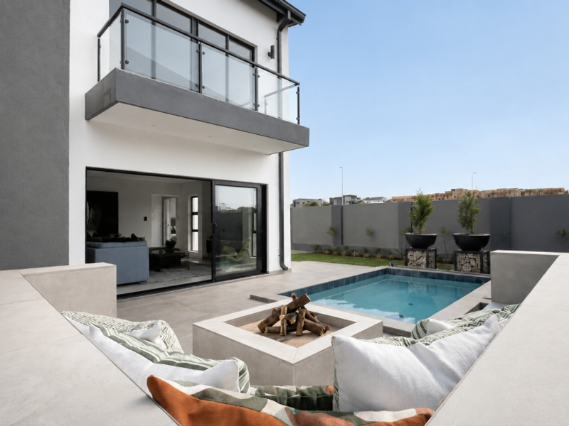 Modern outdoor entertainment area featuring a sunken fire pit, tiled patio, and a swimming pool, with direct access to the home's living space.