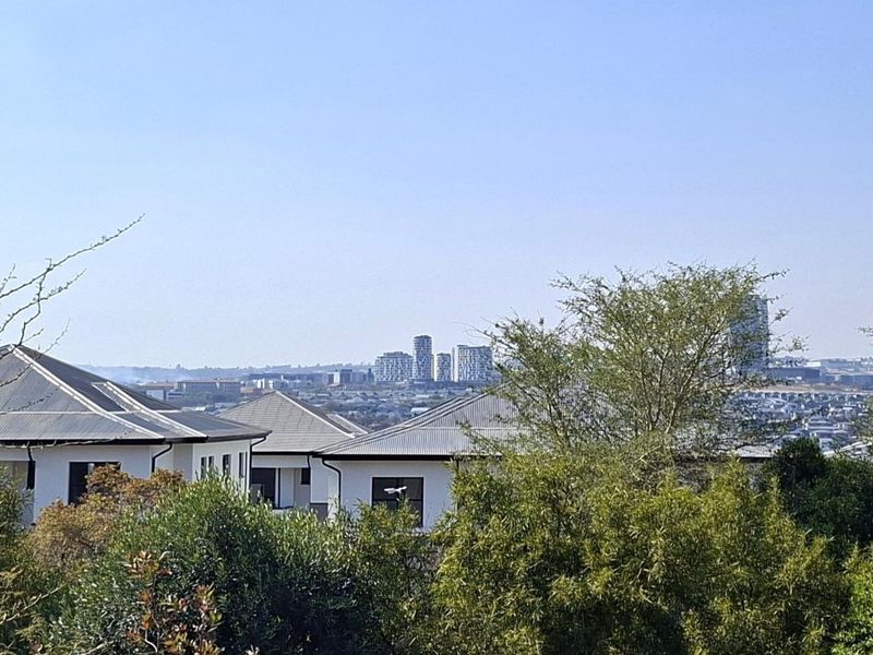 An elevated view overlooking the surrounding residential neighbourhood and distant city skyline.