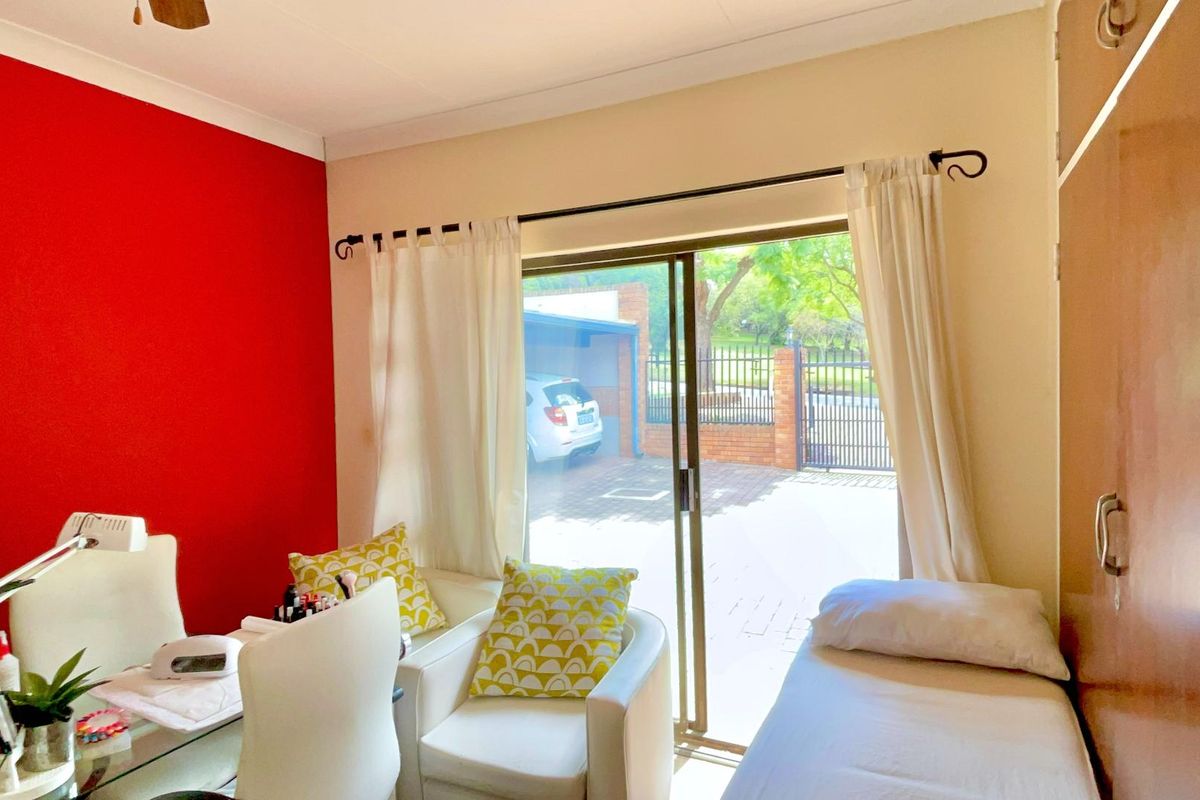 A bedroom featuring a sliding glass door providing direct access to the exterior driveway and garden area.
