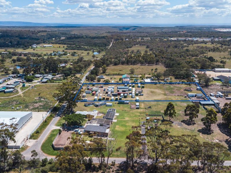 Aerial view of a large vacant residential land parcel with perimeter fencing and surrounding rural landscape.