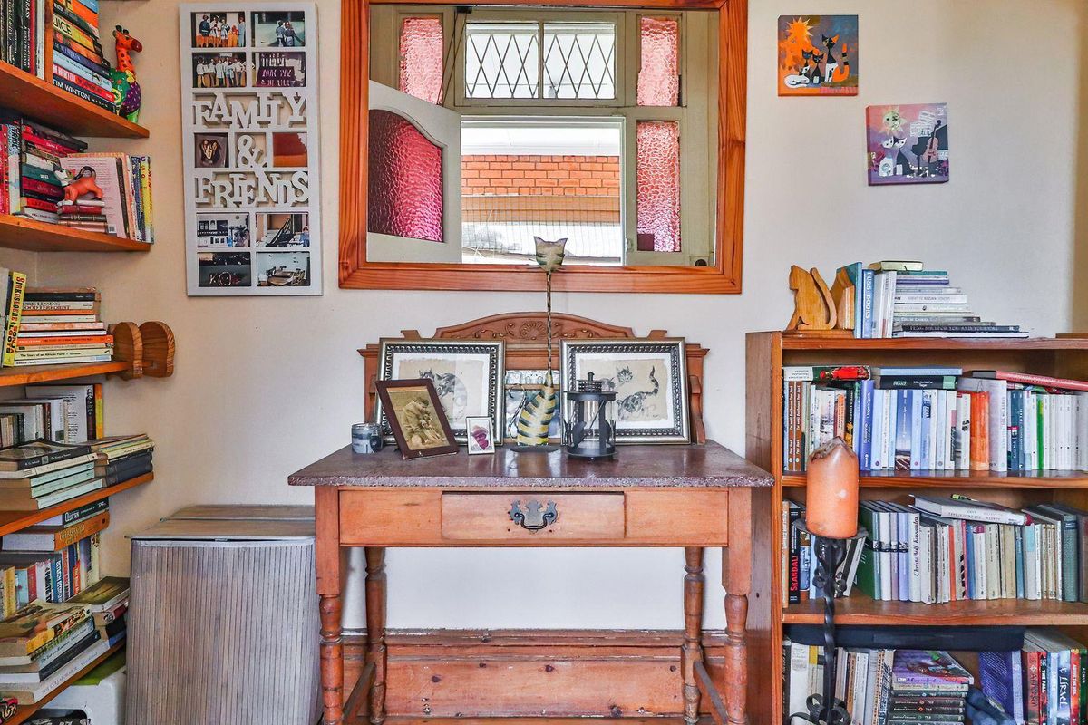 A cozy living area featuring a classic timber-framed window with leaded glass detailing, providing natural light and a traditional aesthetic.