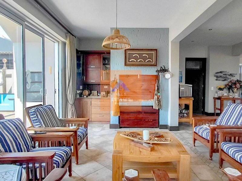 Open plan living area featuring tiled floors, built-in cabinetry, and large sliding glass doors providing seamless access to the outdoor patio area.