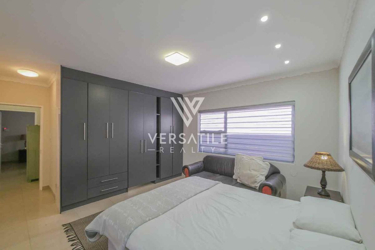 A well-maintained bedroom featuring built-in floor-to-ceiling cabinetry, recessed ceiling lighting, and tiled flooring.