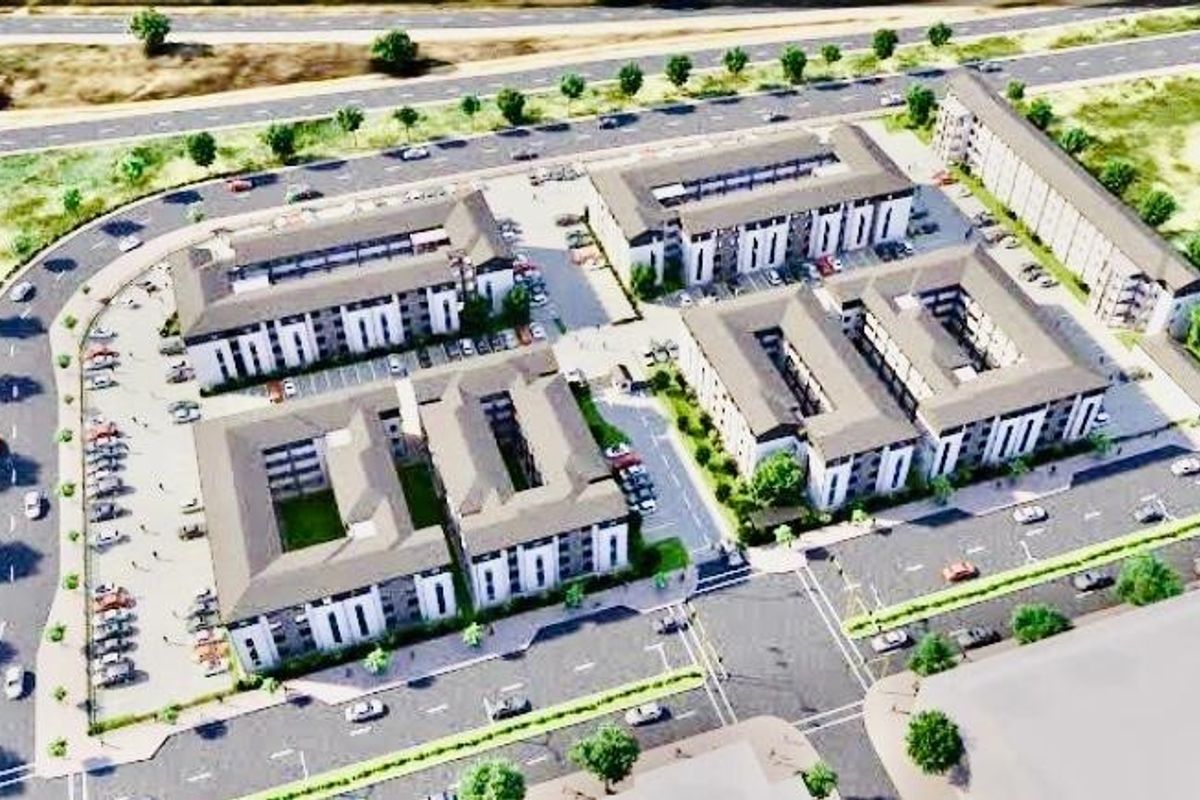 An aerial perspective of a modern townhouse development featuring multiple residential blocks, internal courtyards, and dedicated parking facilities within a landscaped estate.