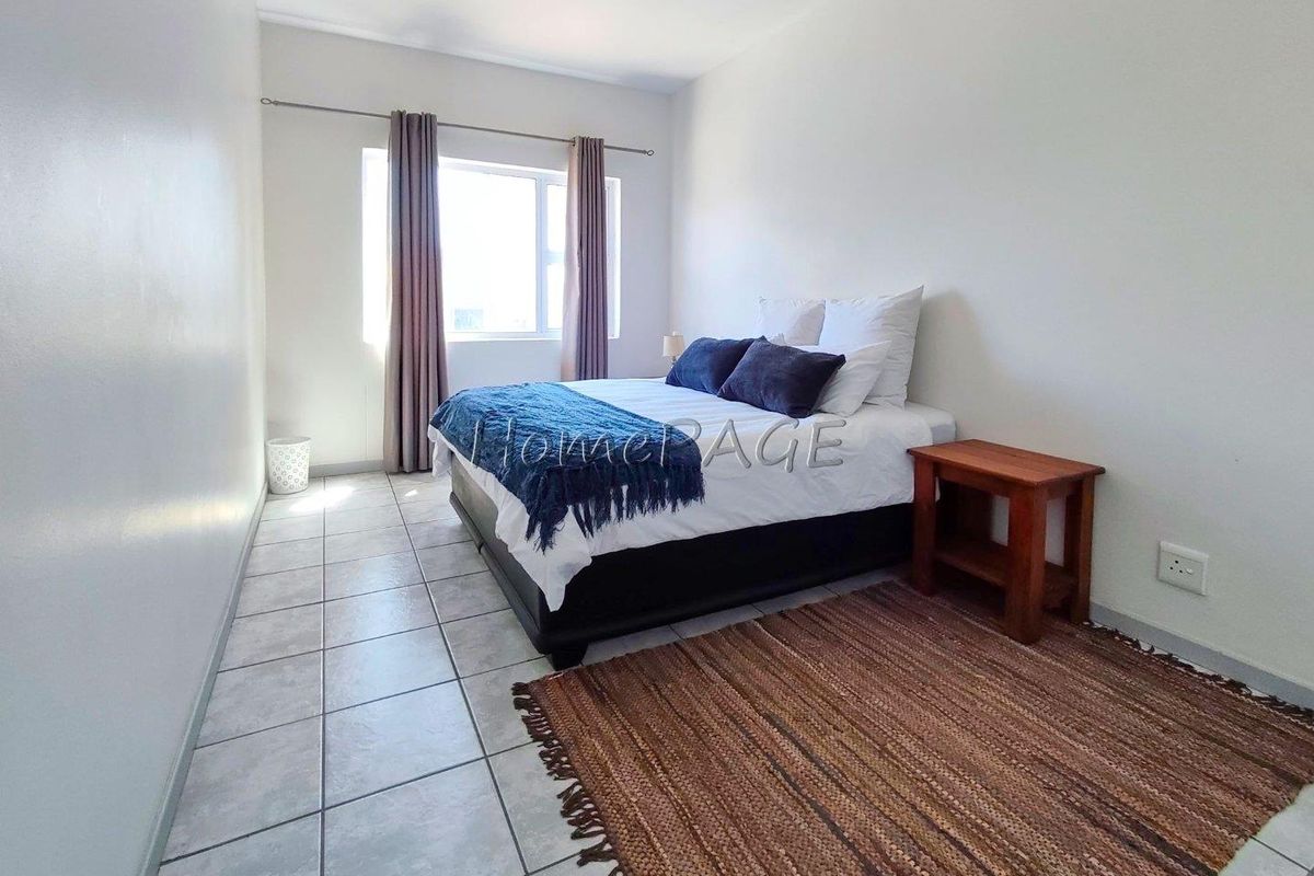 A bedroom featuring tiled flooring, a window with curtain rod, and standard electrical outlets.