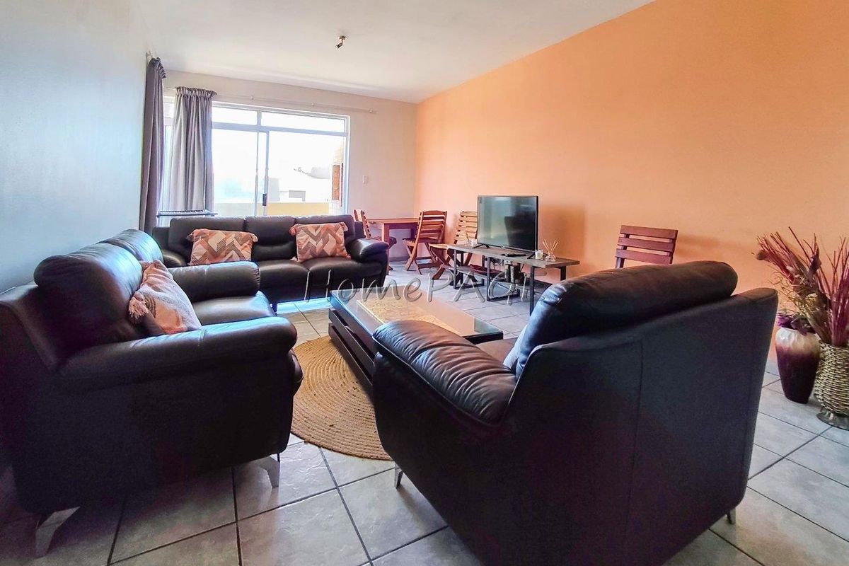 A spacious living area featuring tiled flooring and large sliding glass doors that provide access to an outdoor space.
