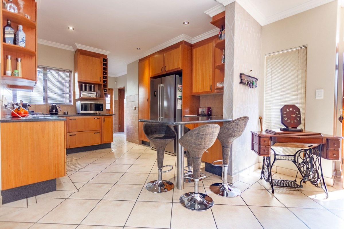 A functional kitchen featuring wooden cabinetry, tiled flooring, and a built-in breakfast nook area with integrated storage.