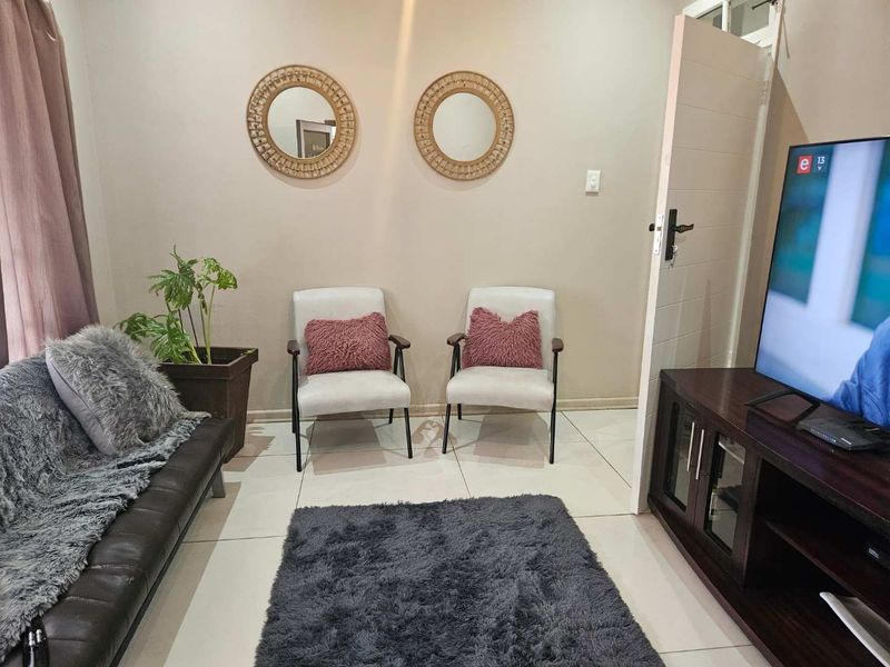 A compact living room featuring neutral wall tones and tiled flooring, providing a functional and comfortable space for relaxation.