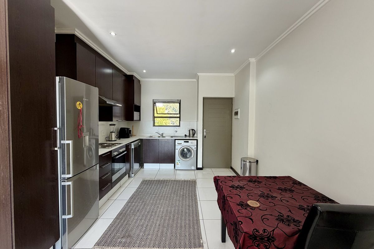 A functional kitchen featuring dark wood cabinetry, stainless steel appliances, tiled flooring, and recessed lighting, offering a clean and practical layout.