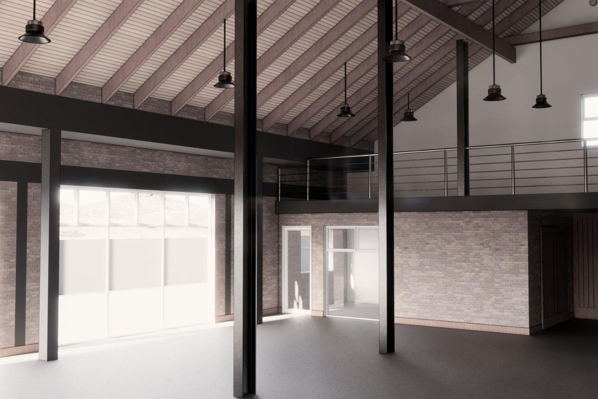 Spacious open-plan industrial interior featuring exposed timber rafters, steel columns, a mezzanine level with metal balustrade, and large windows providing natural light.