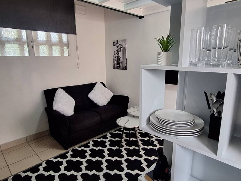 Compact open-plan living area featuring tiled flooring and a neutral color palette, suitable for a modern apartment layout.