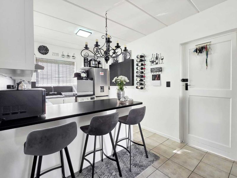 Open plan kitchen and living area featuring a breakfast bar, tiled flooring, and functional built-in cabinetry.