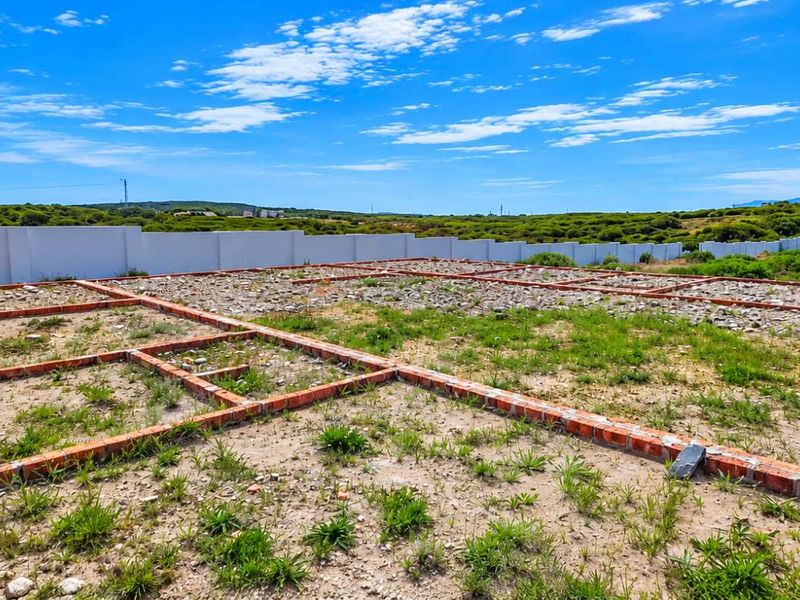 Vacant residential land featuring an existing brick foundation perimeter wall, offering a clear site for future development.