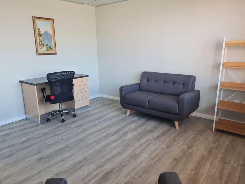 A functional office space featuring modern laminate flooring and a clean, neutral aesthetic suitable for a professional work environment.