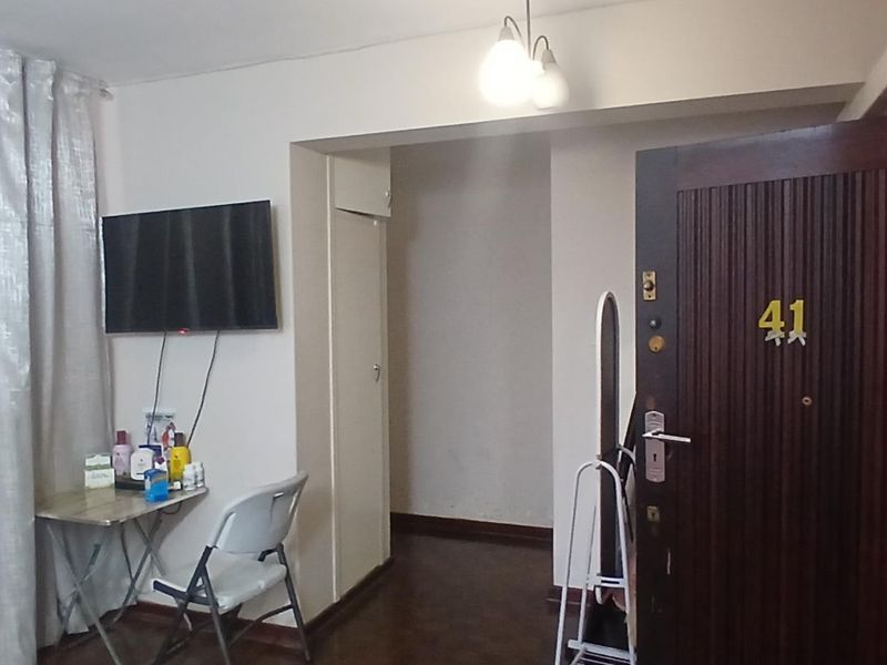 Entrance area featuring a solid timber door, parquet flooring, and a built-in storage cupboard.