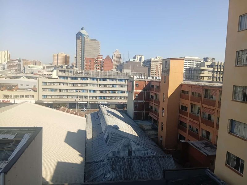 An elevated urban view overlooking surrounding city buildings and rooftops, showcasing the dense metropolitan landscape.