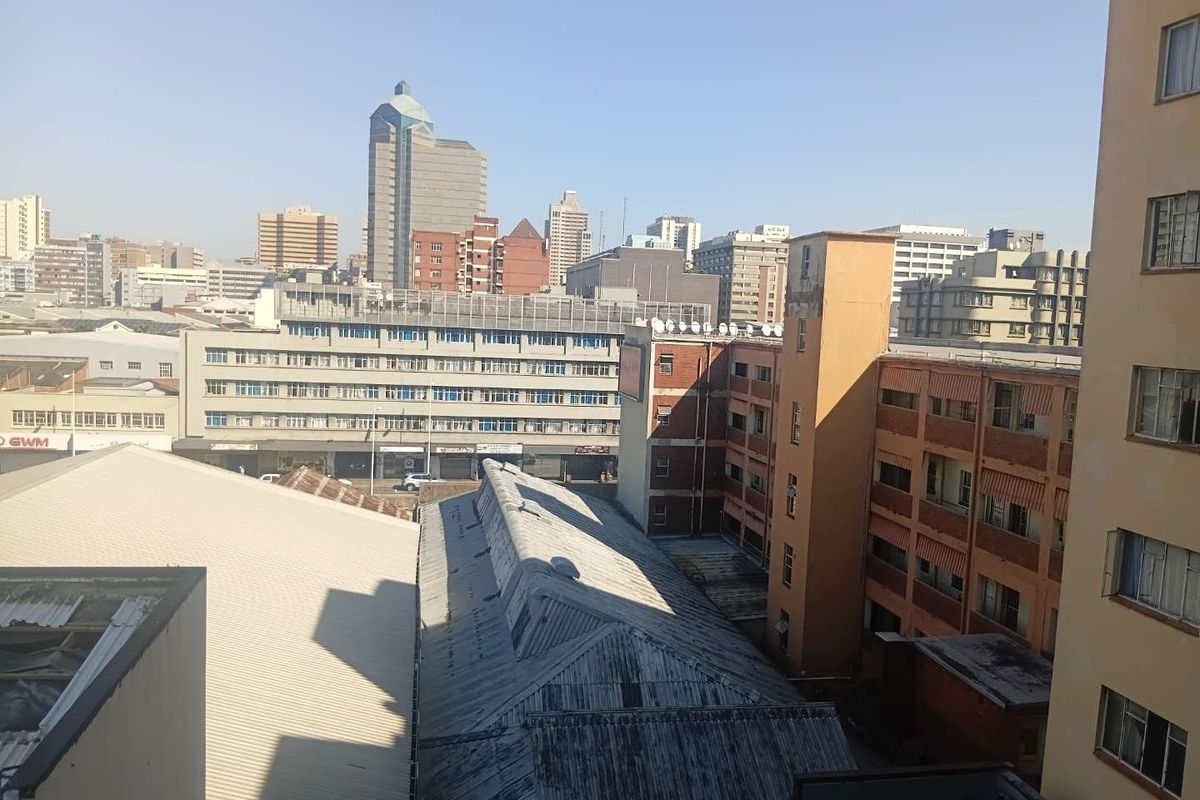 An elevated urban view overlooking surrounding city buildings and rooftops, showcasing the dense metropolitan landscape.